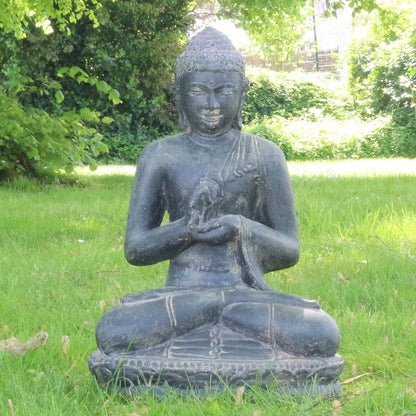 Steinbuddha Frontal im Garten auf einer grünen Wiese